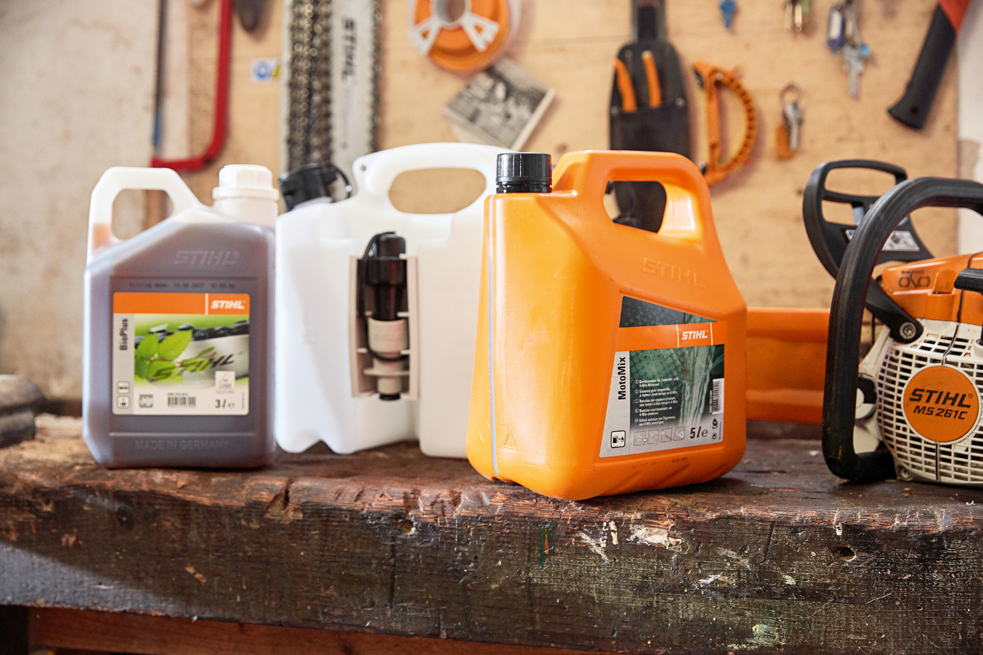 Kanister sa mješavinom za motorne testere STIHL MotoMix, uljem i benzinom i benzinskom motornom testerom STIHL MS 261 C u radionici
