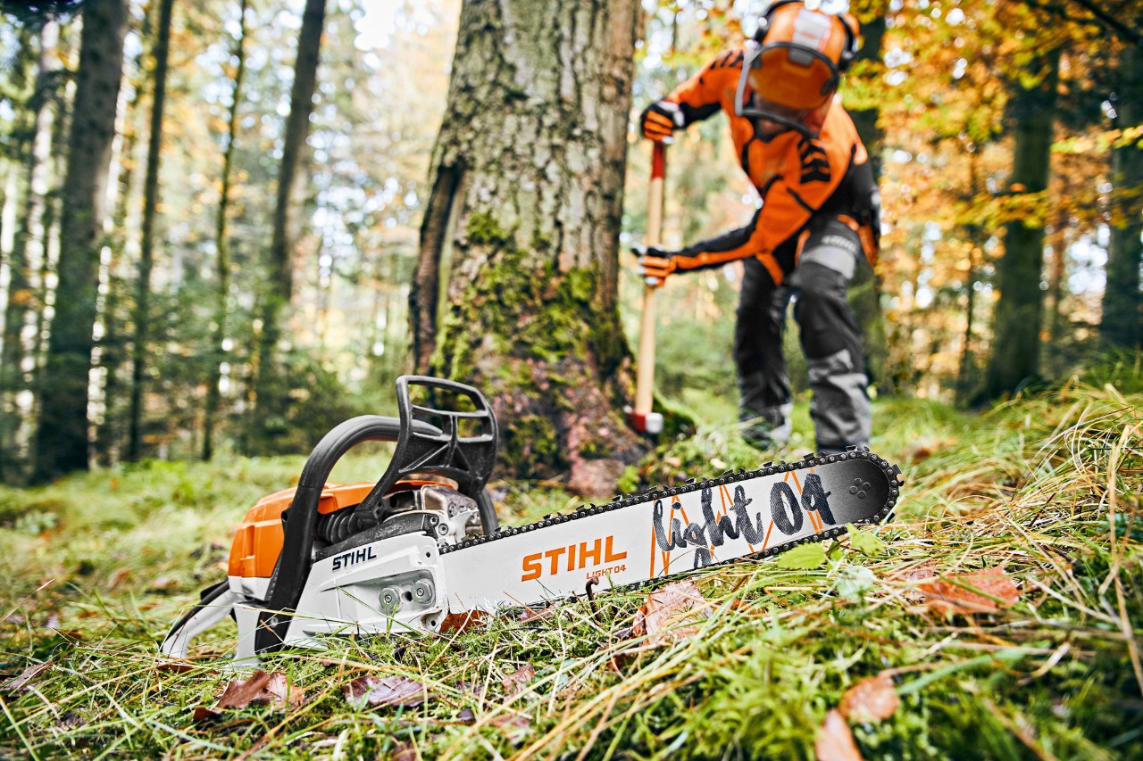 Muškarac u zaštitnoj opremi u šumi, u prednjem planu STIHL benzinska lančana testera MS 261 C-M sa vodilicom Light 04