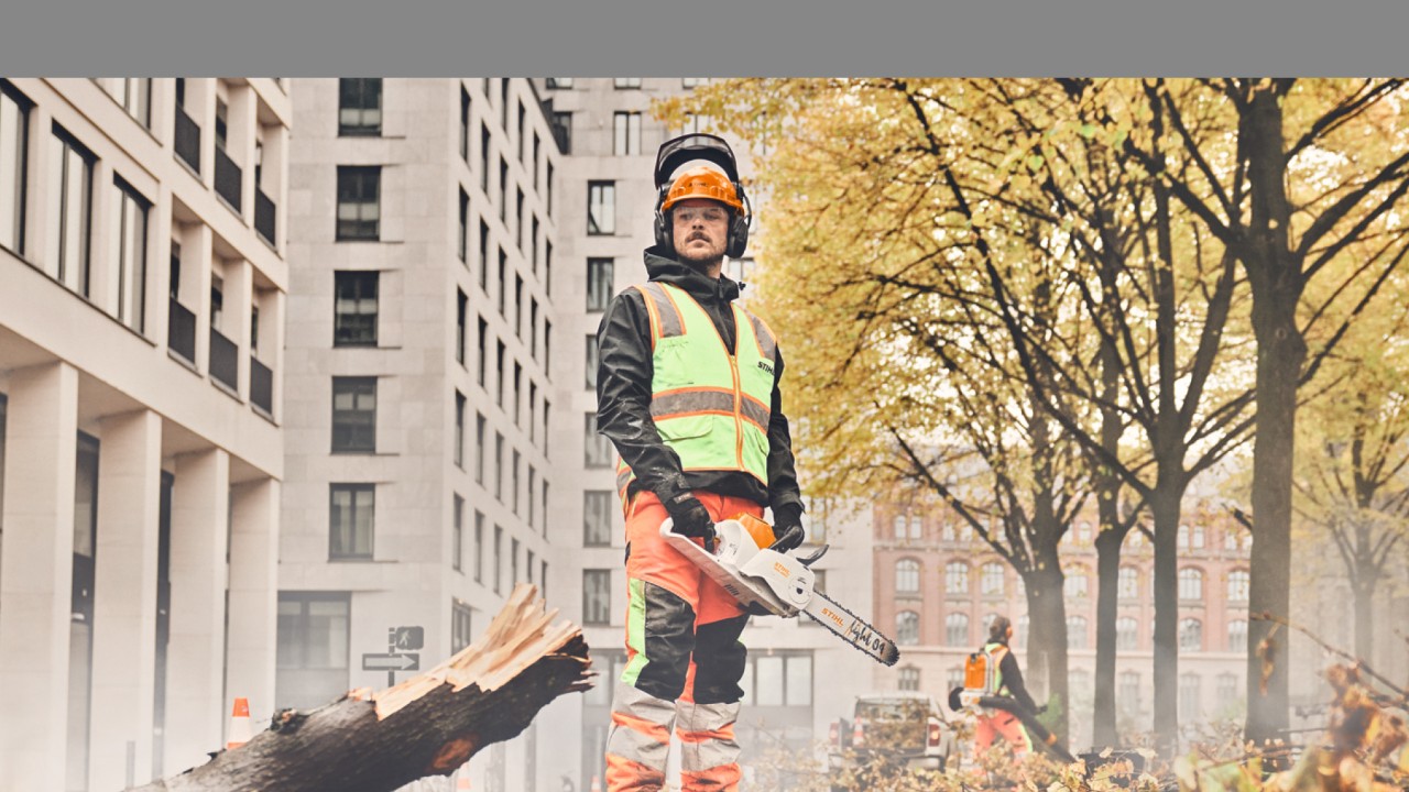 Čovek stoji ispred drveta sa STIHL lančanom testerom