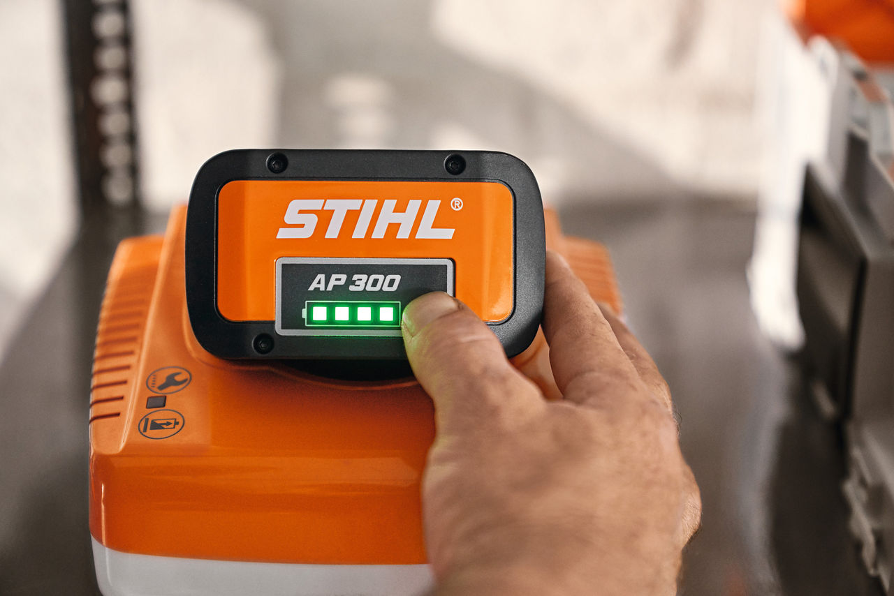 Snimak izbliza kako neko pokazuje na STIHL baterijsku kutiju sa svetlosnim indikatorom 